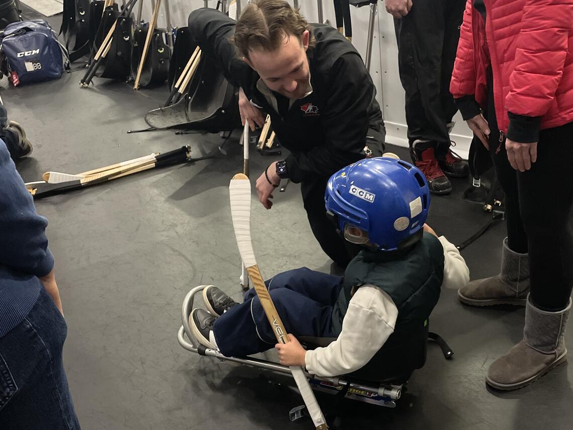 child in sledge with coach talking to child