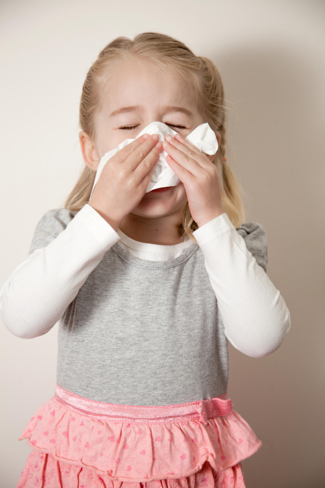 Female child blowing nose Female child blowing nose