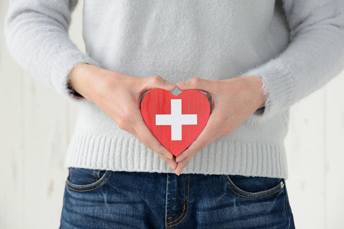 Woman holding heart to her stomach