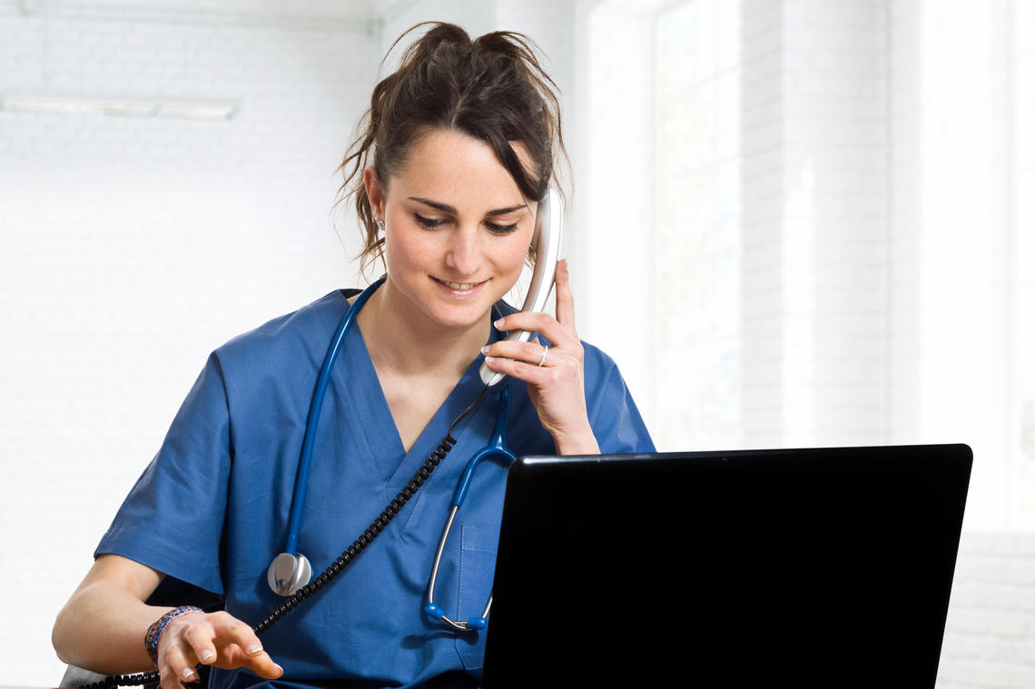 Doctor using a telephone, looking at a screen