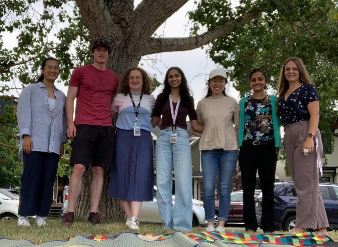 7 lab members standing in front of a tree outside