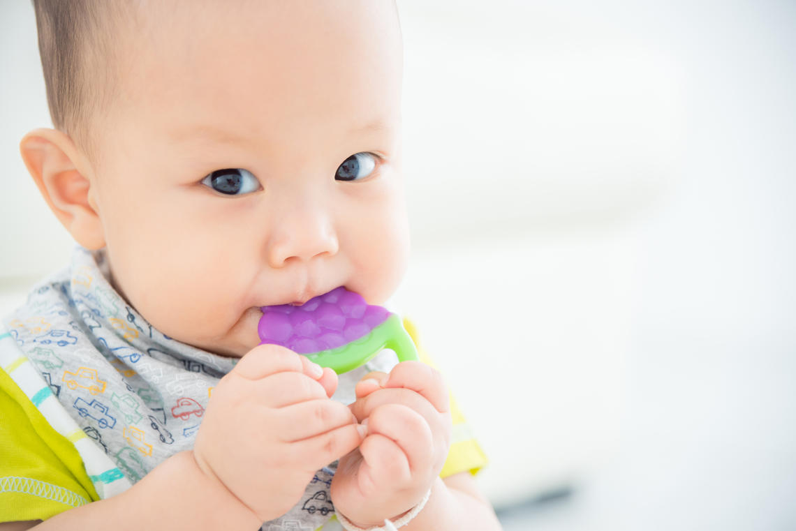 Baby chewing on teething toy