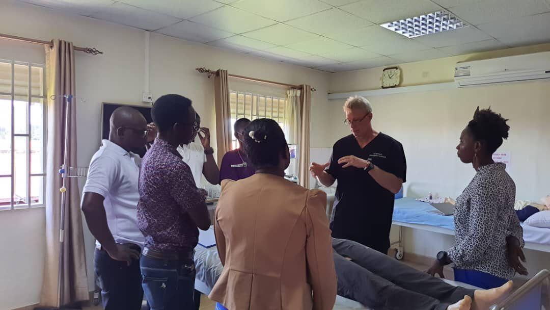 seven people standing in a circle discussing a medical simulation scenario