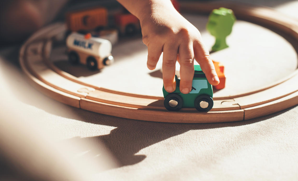 toddler hand playing with train