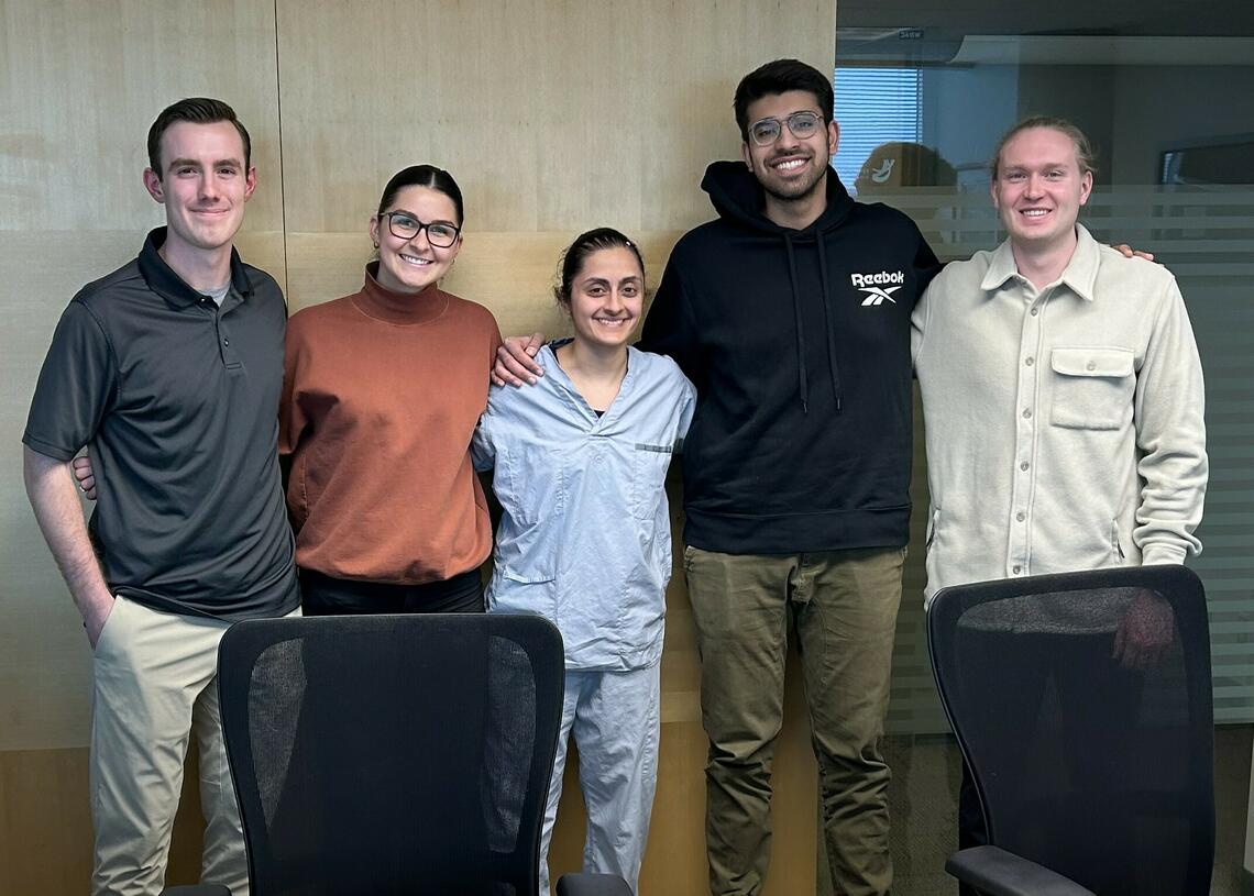 Photo of 5 lab members standing and smiling