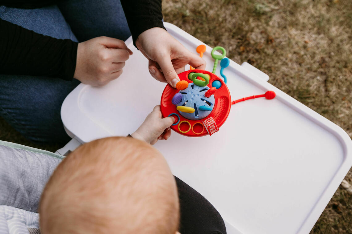 adult and child hands playing with a toy