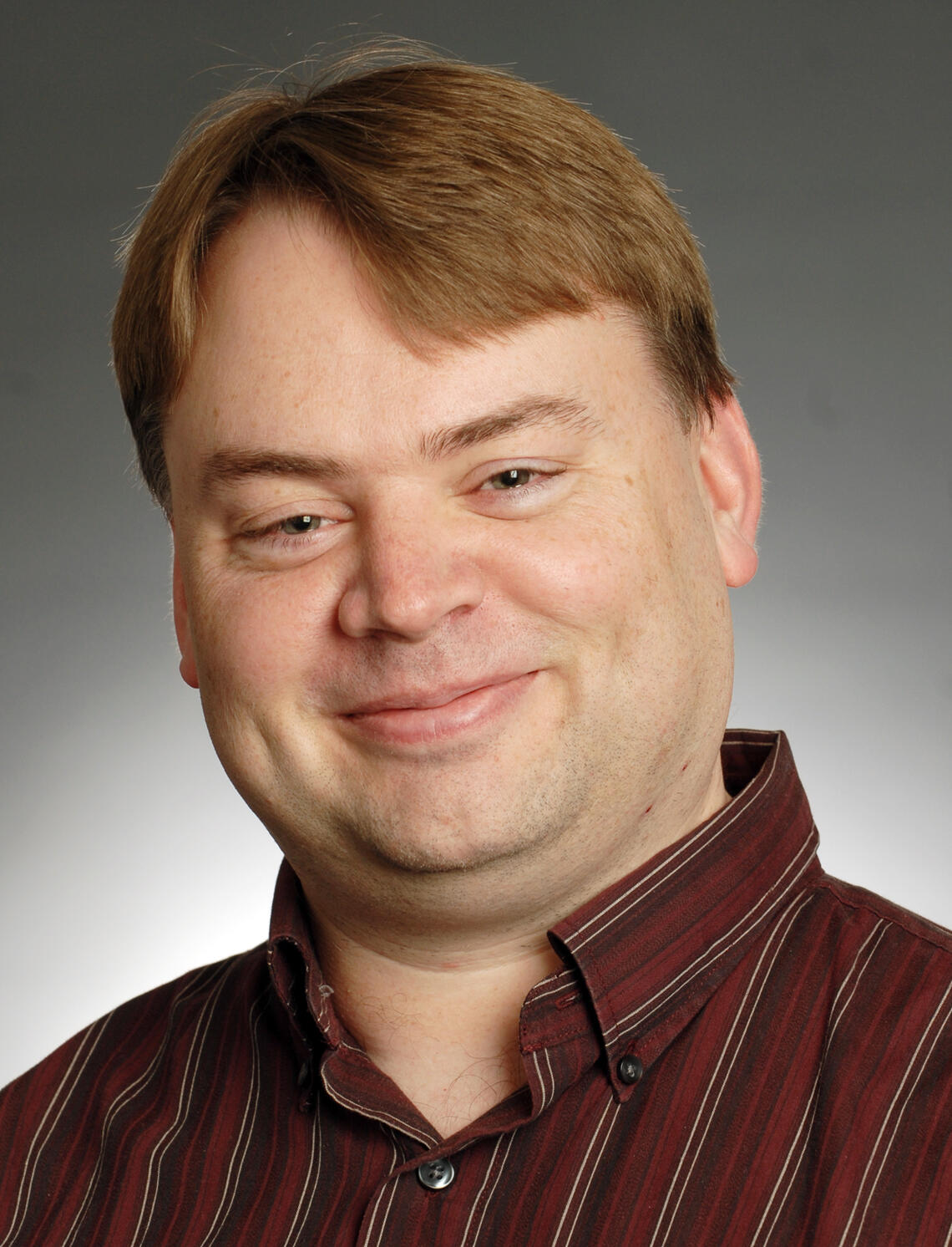 Photo of middle aged Caucasian male with collared burgundy shirt