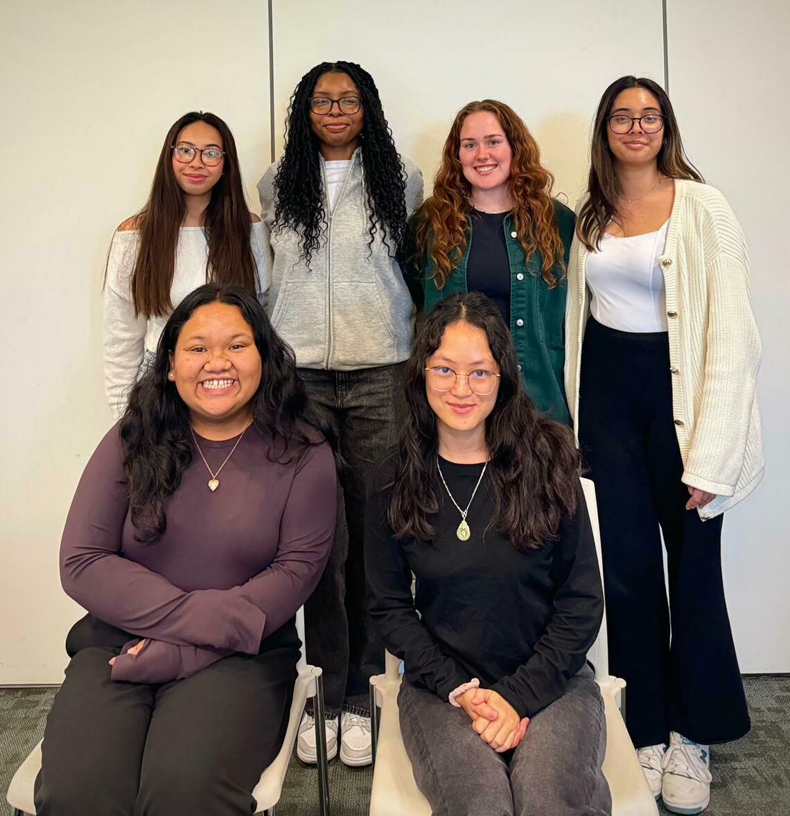 A group photo of 6 students on the CRDS Student Association. 4 women stand in the back and 2 are seated infront of them. Everyone is smiling for the photo!