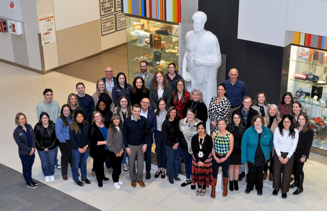Most of the ICDC research team gathered together in front of a statue of Hippocrates laced in the atrium. 