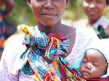 A mother poses with her sleeping baby, Nyamayinza, Misungwi