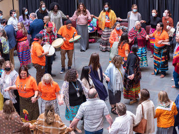 A group of people standing holding hands in a round dance