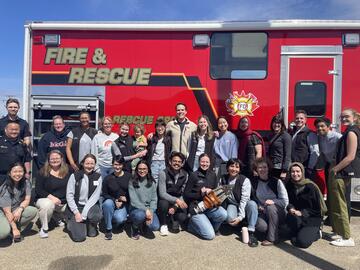 UCLIC students and local Brooks EMS professionals in front of a fire truck
