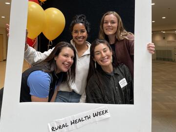 Students posing with a polaroid photo prop at DLRI's rural Health Week 2024 event