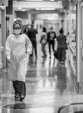 Healthcare worker walking down hospital hallway