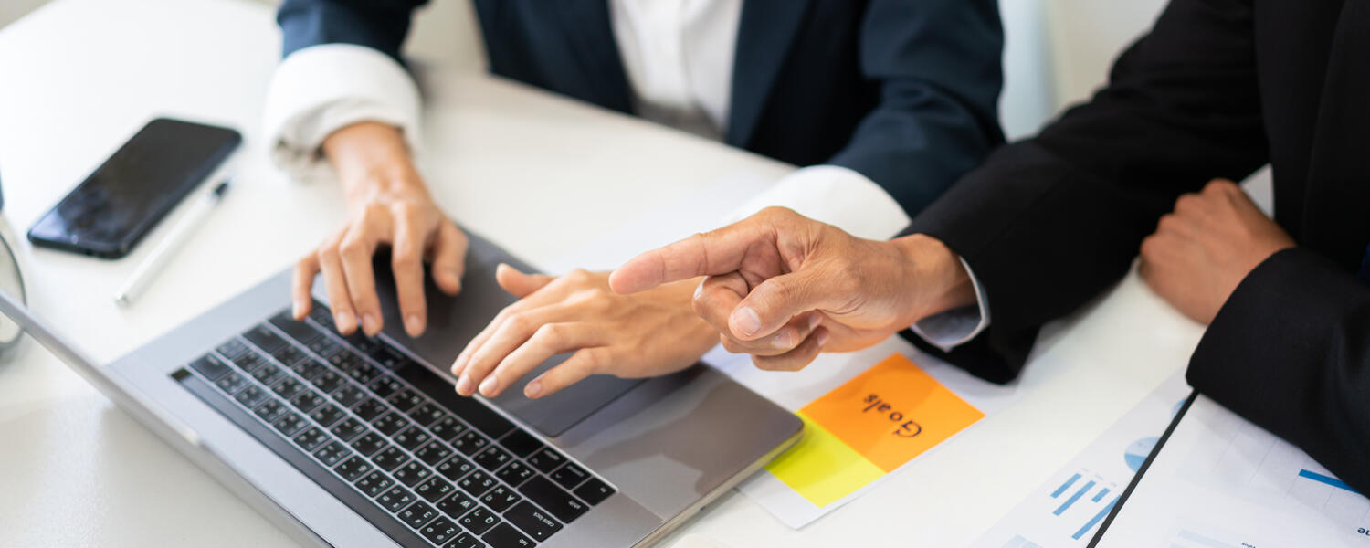 Coworkers pointing at a laptop.
