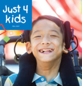 A close up of a boy in a wheelchair smiling