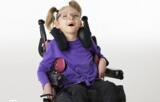 A picture of a young girl smiling in her wheelchair.