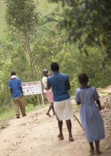 group of five adolescents walking on a dirt road