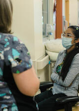 healthcare provider in front of woman with crossed arms