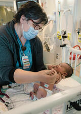 healthcare provider holding newborn baby