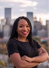 Headshot of Dr. Tito Daodu against a background of the Calgary skyline