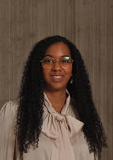 Dr. Case smiles towards the camera. She is wearing a cream coloured blouse with a decorative tied bow at the neck. 