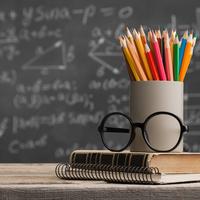 Teachers desk, pencils and glasses