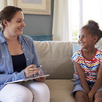 Woman speaking with child sitting down