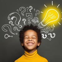 Young boy smiling with questions marks and a light bulb around his head