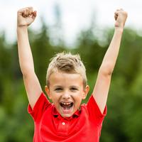 Boy smiling with hands in the air