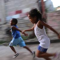 Two children running on sidewalk