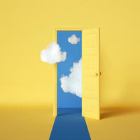Yellow room and door opening onto blue sky and clouds.