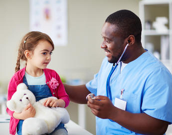 A smiling clinician works with their patient. 
