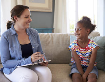 Woman talking to child on a sofa