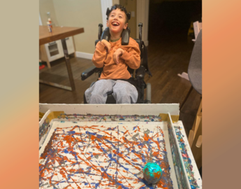 A boy using a BCI and sphero robot toy to paint