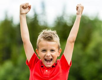 Boy smiling with arms aloft