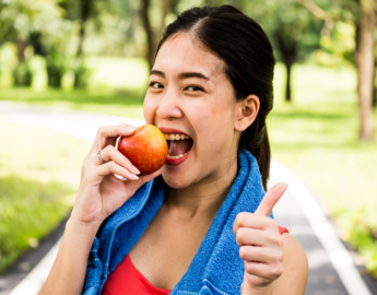 Woman doing exercise and eating and apple