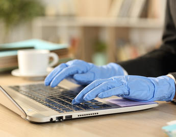Person using a keyboard wearing rubber gloves