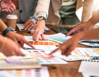 group of people working on a desk together