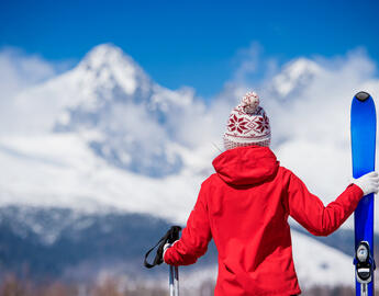 Skier looking out at a large snow capped mountain